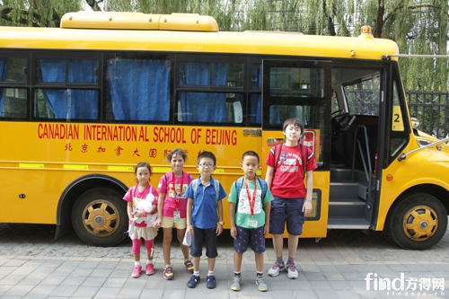 北京加拿大国际学校的学生们与校车合影留念