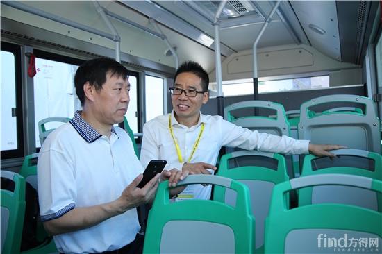 天海集团董事长吕超(右)在向嘉宾介绍轮毂电机客车